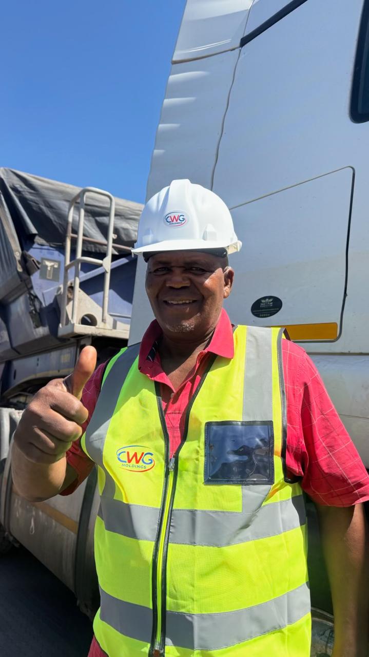 CWG team member in branded safety vest and hard hat, thumbs up